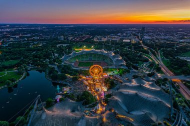 Popüler Olimpiyat Parkı 'nda ve parlayan turuncu bir alacakaranlıkta stadyumda düzenlenen festivalle Münih' te gün batımı harika..