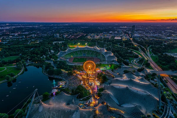 Merveilleux coucher de soleil à Munich depuis une haute vue avec un festival au populaire parc olympique et le stade à un crépuscule orange lumineux. — Photo