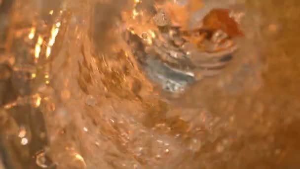 Cerveja derramando em um copo em câmera lenta a 1500 fps macro com respingos e gotas de mesa 1080p — Vídeo de Stock