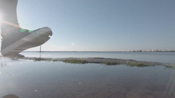 Mulher correndo pisando na água com respingos e gotas em movimento super lento — Vídeo de Stock