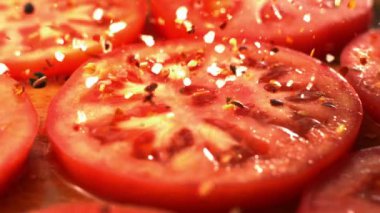 Taze domates dilimleri ve baharatlı sıcak baharat. Ağır çekimde makro atış.