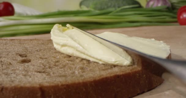 Масло Розтікається Скибочці Хліба Ножем Обробній Дошці Овочами Фоні — стокове відео