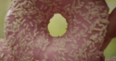 El, Yeşil Arkaplanda Bebek Kameralı Masaya Pembe Çörek Yığını koyar