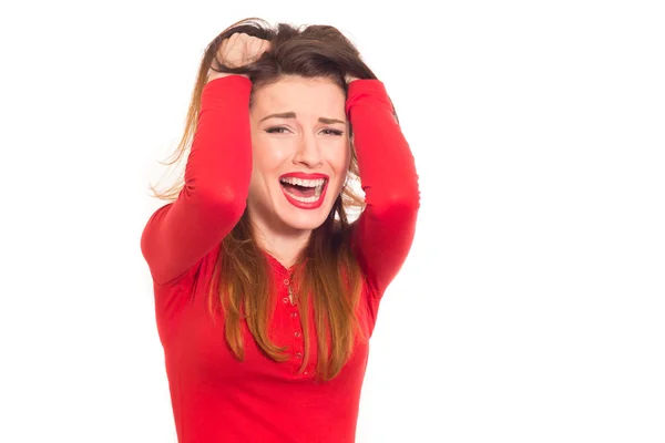 Емоційно напружена жінка в червоному схоплює волосся ізольовано — стокове фото