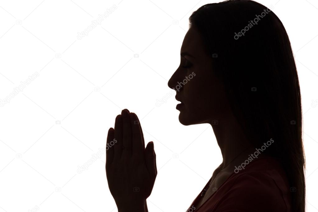Closeup profile of a woman praying in silhouette isolated