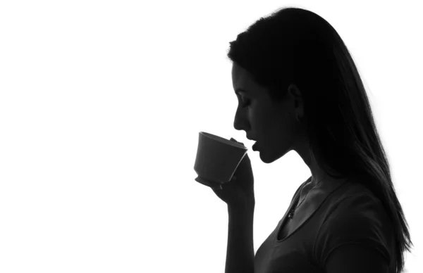 Holding ve kahve ya da çay siyah izole beyaz fincan içme kadın profili