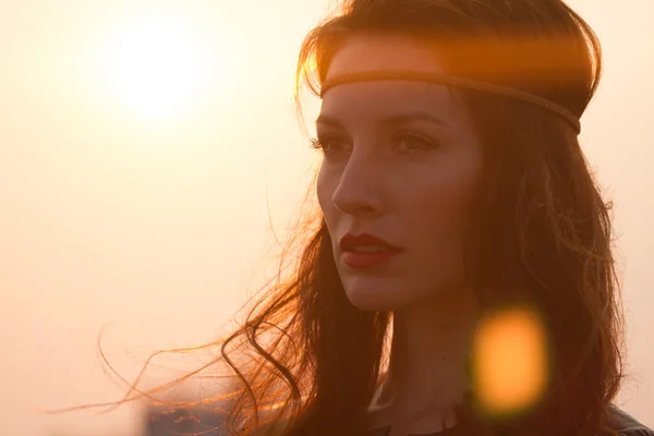 Kafa bandı uzakta ile rüzgarlı saç batımını ile bir hippi kadın portresi.