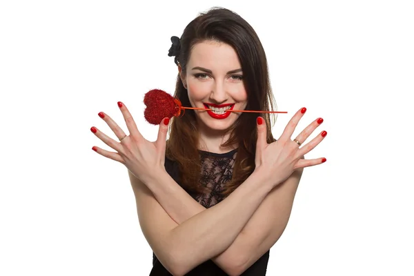 Erotic looking woman with red lipstick holding Valentine heart in her mouth teeth — Stock Photo, Image