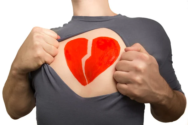 Adam gri t-shirt parçalıyor. Başına boyalı kırık kırmızı kalp 