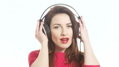 Güzel kız ile birlikte kamera ve shying beyaz arka plan üzerinde izole fark büyük kulaklıklar müzik sallanan kırmızı yakın atış
