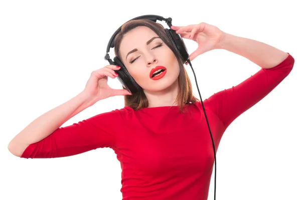 Pretty girl with red lipstick and red clothes listening to the m — Stock Photo, Image