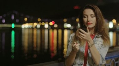 Gece şehir dışında kırmızı ruj koyarak kadın Kiev suda yansıtan ışıklar