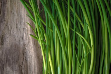 Yeşil soğan saplarını ahşap bir masa üzerinde