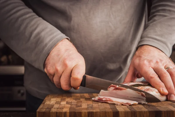 Man snijden reuzel in de keuken — Stockfoto
