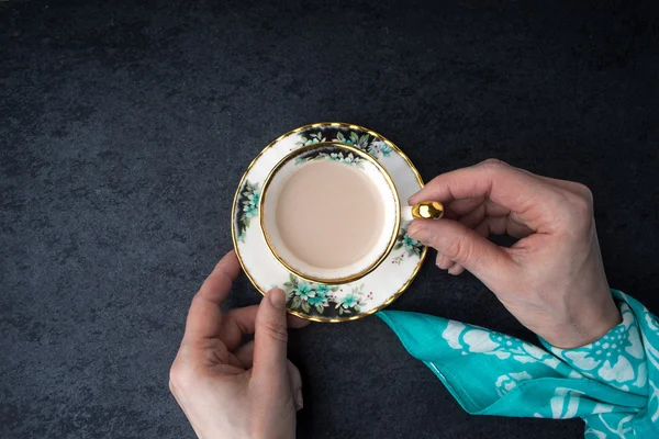 Café com leite no copo de porcelana na vista superior da mão — Fotografia de Stock