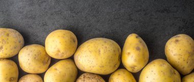 Karanlık taş tablo geniş ekran üzerinde ham patates