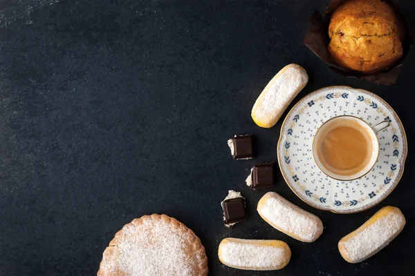 Café con diferentes dulces en la vista superior de la mesa oscura —  Fotos de Stock