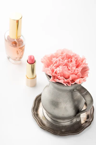 Jarro com perfume de flor e batom na mesa — Fotografia de Stock