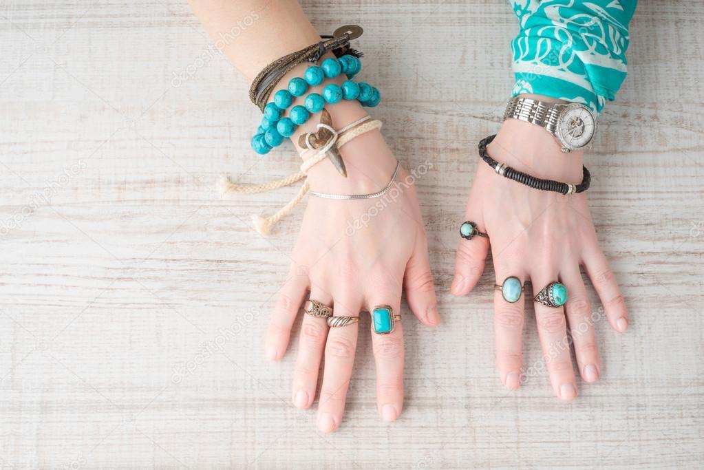 Hands of women in the jewelry of turquoise