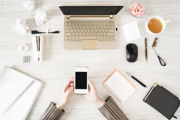 Telefono cellulare in mano sul posto di lavoro — Foto Stock