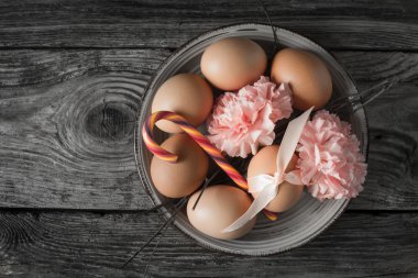 Şerit, dalları, çiçekler ve ahşap masa üstü görünümünde şeker ile yumurta