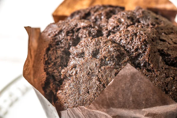 Čokoládový muffin v pergamenu na bílém pozadí — Stock fotografie
