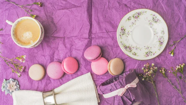 Kopje koffie met bitterkoekjes en decoratie op het paarse papier bovenaanzicht — Stockfoto