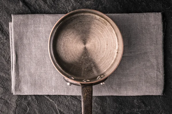 Metalen pan op de weergave van de donkere stenen tafelblad — Stockfoto