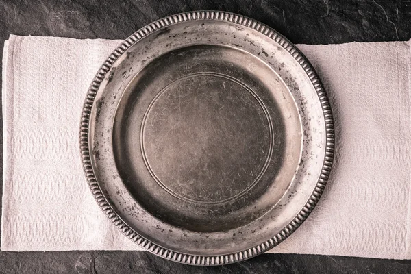 Metal plate on the dark stone table top view — Stock Photo, Image