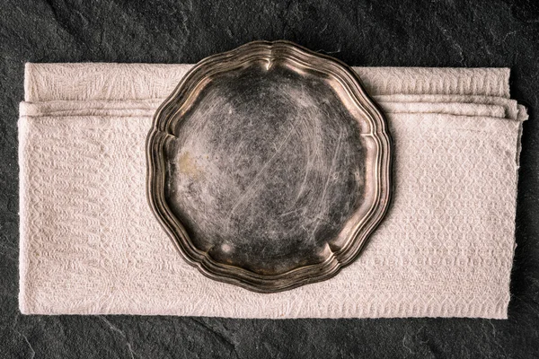 Vintage metal plate on the dark stone table top view — Stock Photo, Image