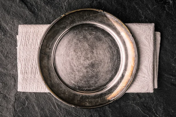 Стара металева тарілка на темному кам'яному столі вид зверху — стокове фото