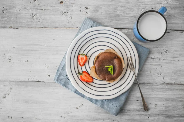 Çilek, nane ve ahşap masa üzerinde süt ile Çikolatalı fondan — Stok fotoğraf