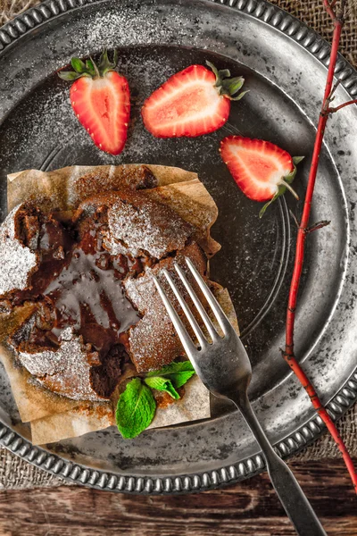 Schokoladenfondant auf der alten Metallplatte senkrecht — Stockfoto