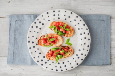 Bruschetta domates ve fesleğen seramik tabak üstten görünüm üzerinde