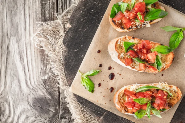 Bruschetta domates ve fesleğen üzerinde ahşap tahta Üstten Görünüm
