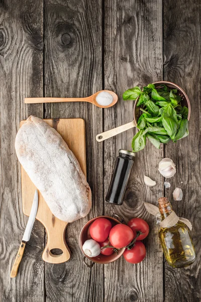 Ingredience pro bruschetta na dřevěný stůl — Stock fotografie