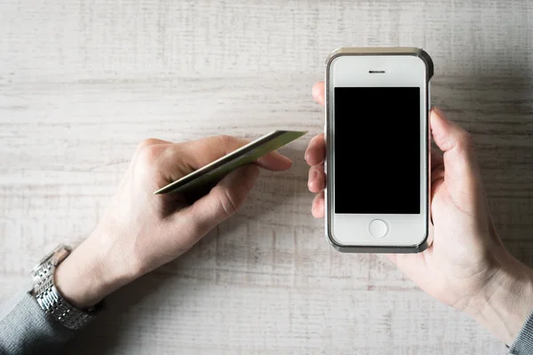 Руки з кредитною карткою і видом зверху на мобільний телефон — стокове фото