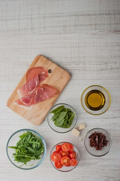 Ингредиенты для салата с ветчиной, помидорами и рукколой — стоковое фото