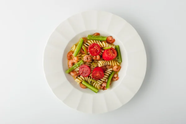 Ensalada con pasta de fusilli con camarones en un plato de cerámica en un wh —  Fotos de Stock