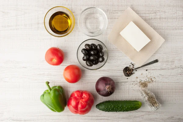 Ingrediënten voor een Griekse salade op een houten tafel — Stockfoto