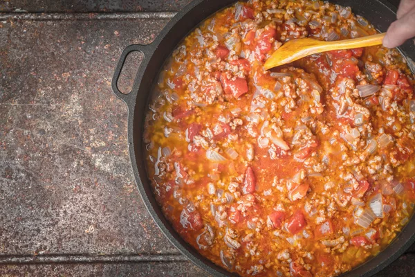 Duszone mięso z cebulą i pomidorami w widoku z góry patelni — Zdjęcie stockowe