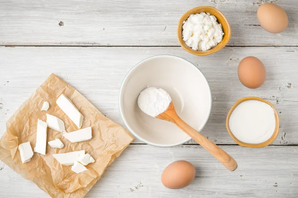 Different fresh cheese with yogurt and eggs on the white wooden table — Stock Photo, Image