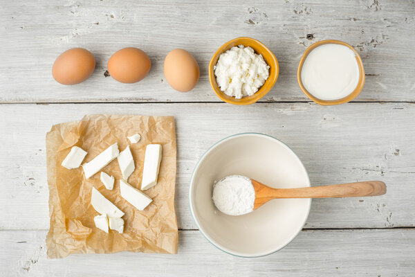 Different fresh cheese with yogurt and eggs on the white wooden table top view