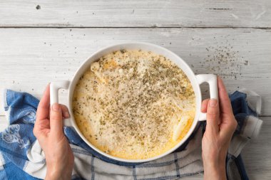 El üst bölümünde seramik tavada ham musakka