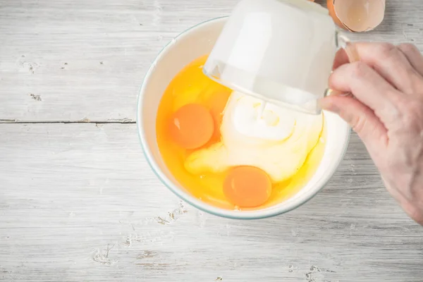 Mixing eggs and yogurt in the ceramic bowl top view — Stock Photo, Image