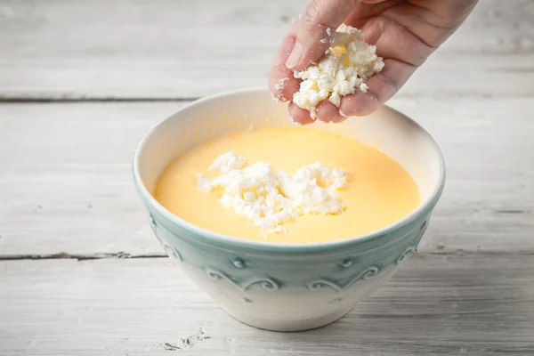Adicionando queijo fresco no topo dos ovos — Fotografia de Stock