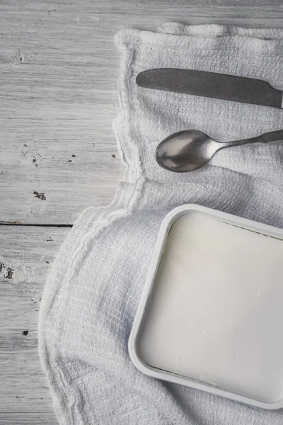 Feta con cubiertos y servilleta en la mesa de madera blanca vertical — Foto de Stock