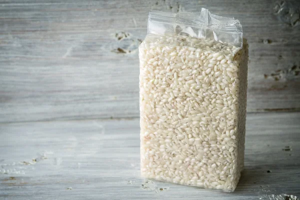 Packaging with Arborio rice on wooden boards — Stock Photo, Image