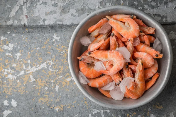 Shrimp and ice in the aluminum bowl on an old metal — Stock Photo, Image