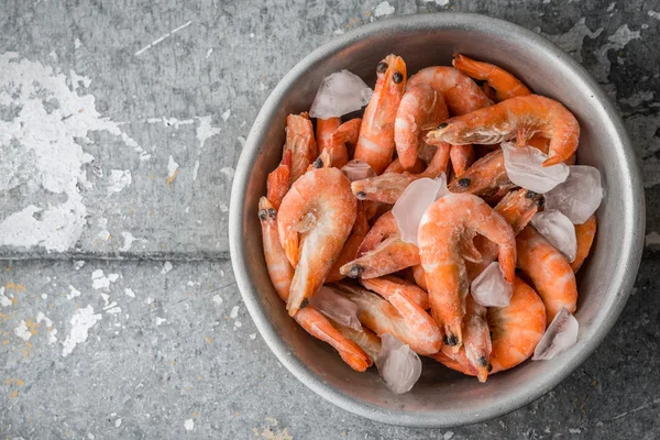 Shrimp and ice in the aluminum bowl on a metal background — Stock Photo, Image